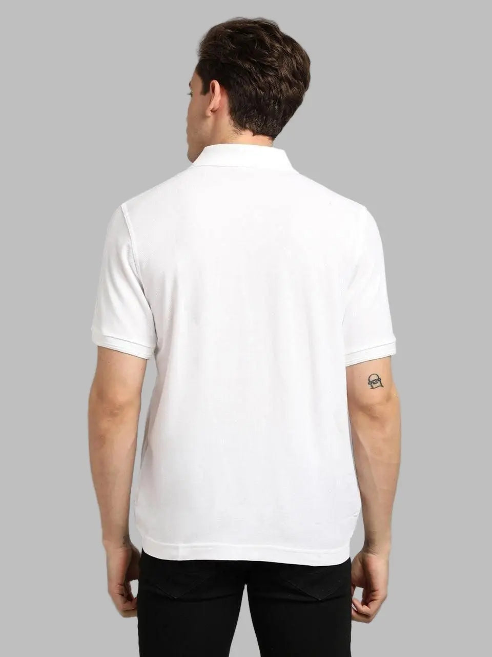 Man wearing a white polo shirt on a gray background