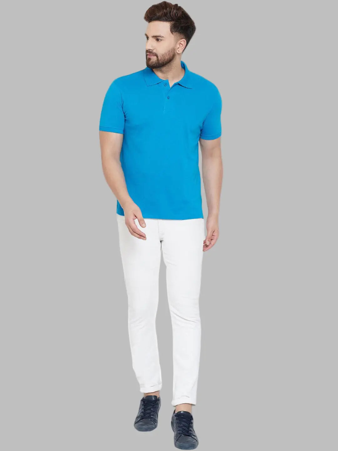 Man wearing a blue polo shirt and white pants on a white background