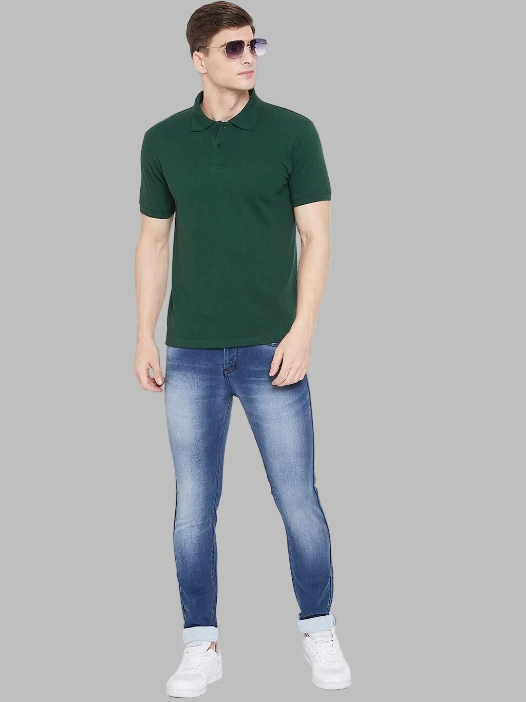 Man wearing a green polo shirt and blue jeans on a white background