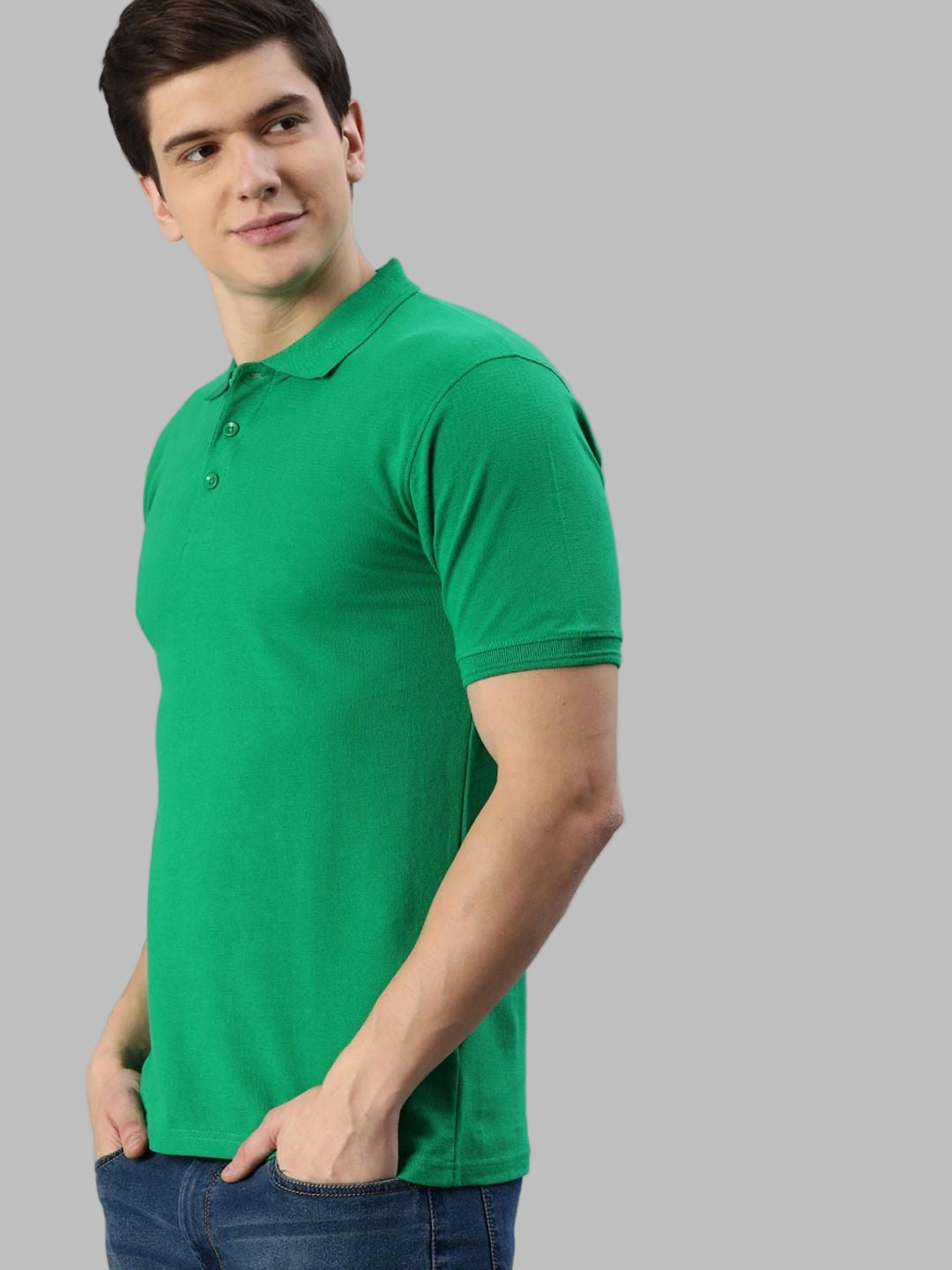 Man wearing a green polo shirt against a gray background