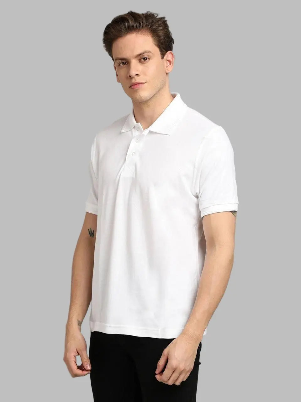 Man wearing a white polo shirt against a gray background