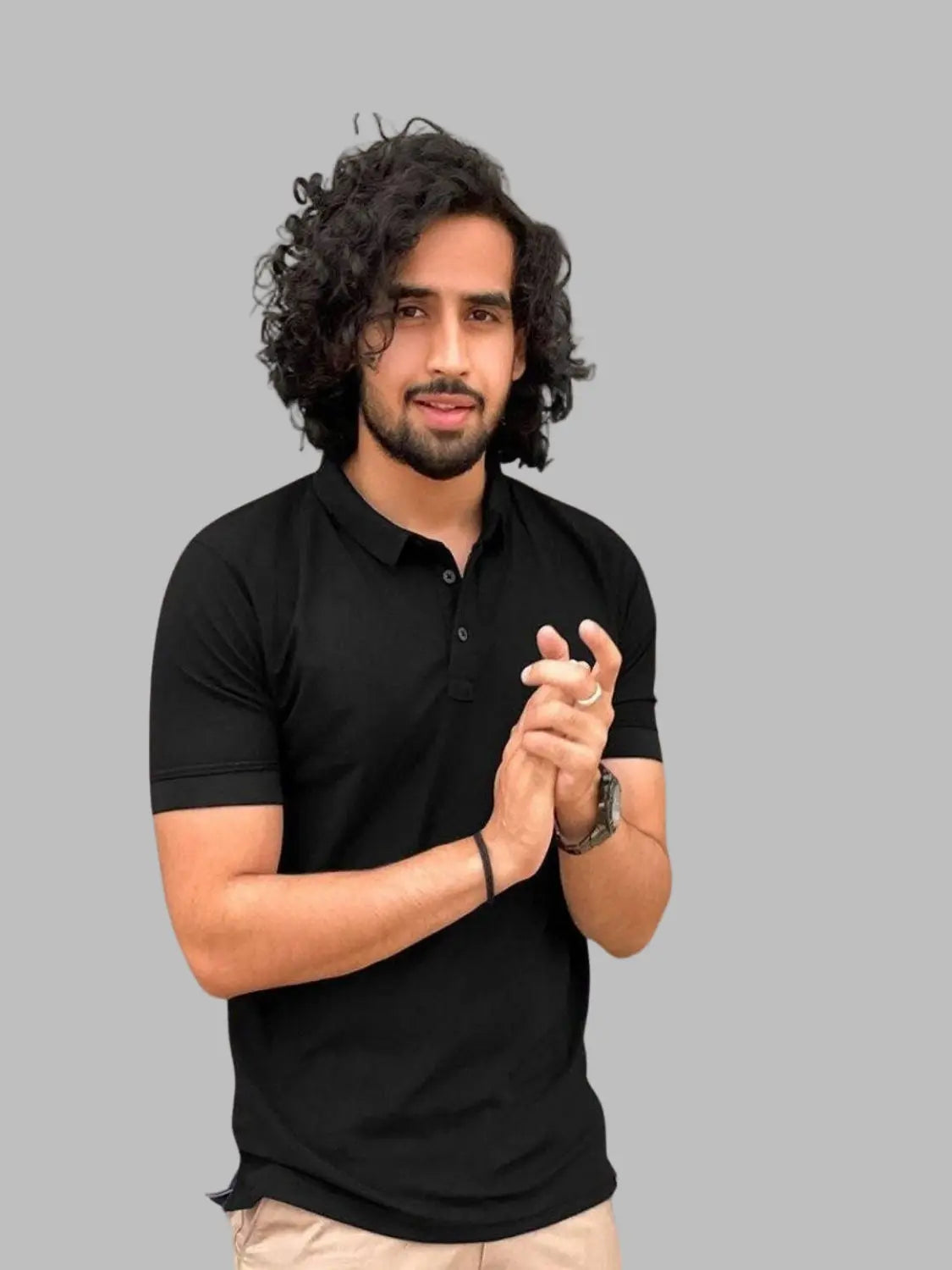 Man wearing a black polo shirt with inset images of shirts on a beige background