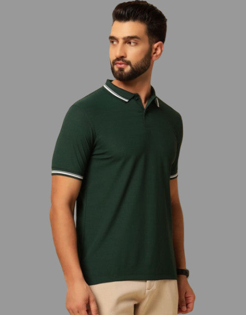 Man wearing a green polo shirt with a beige background