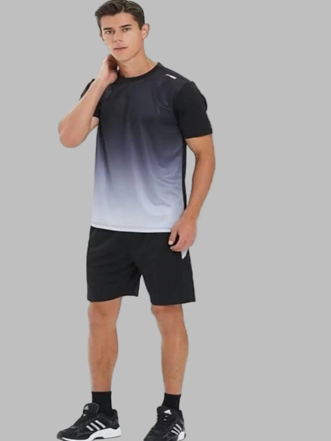 Man wearing a black and gray gradient t-shirt with black shorts on a white background