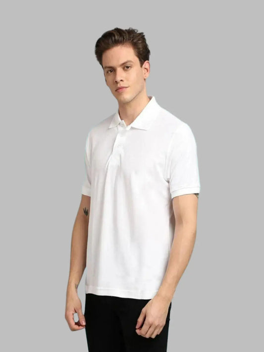 Person wearing a white polo shirt against a light blue background